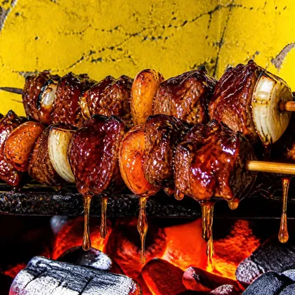 Sosaties dripping sticky basting sauce onto glowing coals